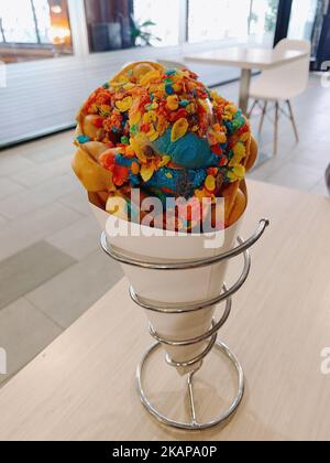 Eine vertikale Nahaufnahme einer köstlichen Blasenwaffel mit Eis und einem farbenfrohen Belag Stockfoto