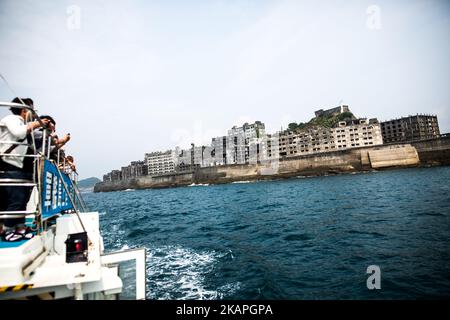 Touristen schauen sich am 8. August 2017 die Insel Hashima an, die gemeinhin als Gunkanjima oder „Schlachtschiffinsel“ in der Präfektur Nagasaki im Süden Japans bekannt ist. Die Insel war bis zu ihrer Schließung im Jahr 1974 ein Kohlebergbaubetrieb und ist ein Symbol für die schnelle Industrialisierung Japans, die auch an ihre dunkle Geschichte als Ort der Zwangsarbeit während des Zweiten Weltkriegs erinnert. Die Insel ist heute als UNESCO-Weltkulturerbe der japanischen Meiji-Industriellen Revolution anerkannt. (Foto von Richard Atrero de Guzman/NurPhoto) *** Bitte nutzen Sie die Gutschrift aus dem Kreditfeld *** Stockfoto