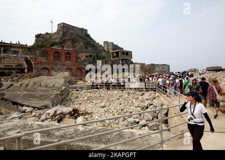 Am 8. August 2017 besuchen Touristen die Insel Hashima, die gemeinhin als Gunkanjima oder „Schlachtschiffinsel“ in der Präfektur Nagasaki im Süden Japans bekannt ist. Die Insel war bis zu ihrer Schließung im Jahr 1974 ein Kohlebergbaubetrieb und ist ein Symbol für die schnelle Industrialisierung Japans, die auch an ihre dunkle Geschichte als Ort der Zwangsarbeit während des Zweiten Weltkriegs erinnert. Die Insel ist heute als UNESCO-Weltkulturerbe der japanischen Meiji-Industriellen Revolution anerkannt. (Foto von Richard Atrero de Guzman/NurPhoto) *** Bitte nutzen Sie die Gutschrift aus dem Kreditfeld *** Stockfoto