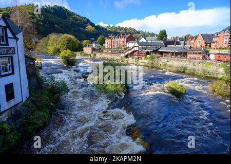 Blick hinunter auf den Fluss Dee in Llangollen, Wales an einem hellen Herbsttag, an dem das Wasser unter den Felsen rauscht und schäumt, wenn es über die Felsen fällt. Stockfoto