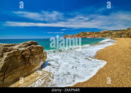 Sonniger Sommertag am Kies- und Sandstrand, Wellen, Spray, Felsen. Stockfoto