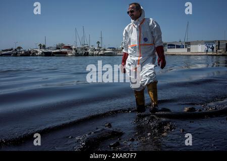 Ein kommunaler Arbeiter versucht, die Ölpest des griechischen Tankers Agia Zoni II, der vor der Insel Salamis an einem der Strände der Riviera von Athen versank, einzudämmen. Athen, Den 14. September 2017. Der kleine Tanker 'Agia Zoni II' sank am 10. September, während er vor der Küste von Salamis in der Nähe des griechischen Haupthafens Piräus vor Anker ging. Es trug eine Ladung von 2.200 Tonnen Heizöl und 370 Tonnen Meeresgasöl. Die Insel Salamis wurde durch eine von Beamten so genannte „große Umweltkatastrophe“ stark verschmutzt. (Foto von Kostis Ntantamis/NurPhoto) Stockfoto