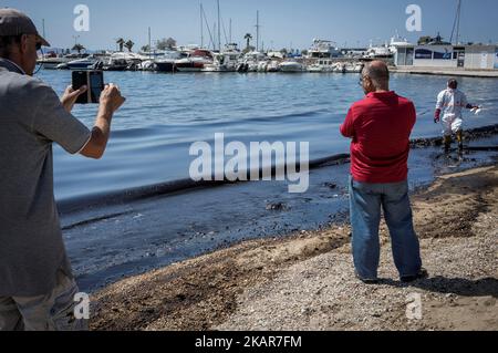 Stadtarbeiter versuchen zusammen mit Freiwilligen, die Ölpest des griechischen Tankers Agia Zoni II, der vor der Insel Salamis an den Stränden von Glyfada und anderen Teilen der Riviera von Athen versank, einzudämmen. Athen, Den 14. September 2017. Der kleine Tanker 'Agia Zoni II' sank am 10. September, während er vor der Küste von Salamis in der Nähe des griechischen Haupthafens Piräus vor Anker ging. Es trug eine Ladung von 2.200 Tonnen Heizöl und 370 Tonnen Meeresgasöl. Die Insel Salamis wurde durch eine von Beamten so genannte „große Umweltkatastrophe“ stark verschmutzt. (Foto von Kostis Ntanta Stockfoto