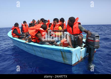 LAMPEDUSA, ITALIEN - SEPTEMBER 02: Flüchtlinge und Migranten warten darauf, von einem überfüllten kleinen Holzboot zu einem Irischen Kriegsschiff überführt zu werden, nachdem sie von Such- und Rettungscrew-Mitgliedern der deutschen NGO Sea-Eye etwa 46 Seemeilen (nm) von einem überfüllten kleinen Holzboot unterstützt und mit Rettungswesten und Trinkwasser versorgt wurden 2, 2017. Die Sicherheitslage für SAR-NGOs wie Sey-Eye hat sich verschlechtert, nachdem die so genannte libysche Kostengarde ihr Such- und Rettungsgebiet von 12nm auf 72nm erweitert hat. Gleichzeitig hat die Zahl der geretteten Menschen aus der Not von NGOs b Stockfoto