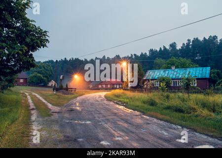 Schönes, altes, polnisches Dorf mit traditionellen landwirtschaftlichen Gebäuden, das am Abend mitten im Wald liegt. Krasnobród, Roztocze, Pol Stockfoto