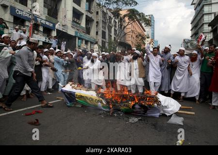 Muslime in Bangladesch verbrennen am 15. September 2017 den Sarg von Aung San Suu Kyis und die Nationalflagge von Myanmar, um gegen die Tötung von Rohingya-Muslimen in Rakhine-Staaten in Dhaka, Bangladesch, zu protestieren. Etwa 400.000 Rohingya flohen nach Bangladesch, um den laufenden Militäroperationen Myanmars zu entkommen. Mehr als 370.000 Rohingya, darunter viele Frauen und Kinder, sind seit August 25 nach Bangladesch geflohen, um der Gewalt zu entgehen, so die Vereinten Nationen, durchschnittlich fast 20.000 pro Tag. (Foto von Monirul Alam/NurPhoto) Stockfoto