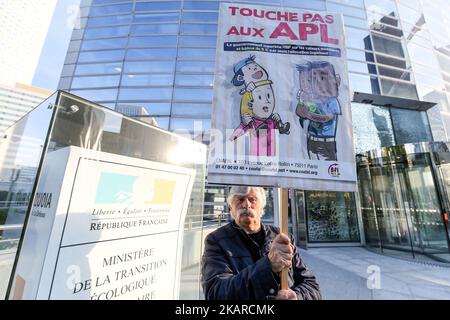 Ein Mann hält am 21. September 2017 ein Schild mit der Aufschrift ‘Don’t tuch to APL’dging bei einer Demonstration gegen die Reduzierung der Wohnungsleistung um €5 pro Monat vor dem Ministerium für territorialen Zusammenhalt im Geschäft des Distrikts La Defense in der Nähe von Paris, Frankreich. Auch die Wohnungsbauleistungen, in Frankreich als APL (Aide personnalisée au logement) bekannt, werden gekürzt. In einer Regierungserklärung vor dem französischen Fernsehen hieß es, dass die Wohnraumvorteile für jeden Antragsteller ab Oktober 2017 um €5 pro Monat reduziert werden. Zu den von den Kürzungen betroffenen Personen gehören 800.000 Studenten, die etwa €225 pro Monat erhalten, von denen mehrere nahmen Stockfoto