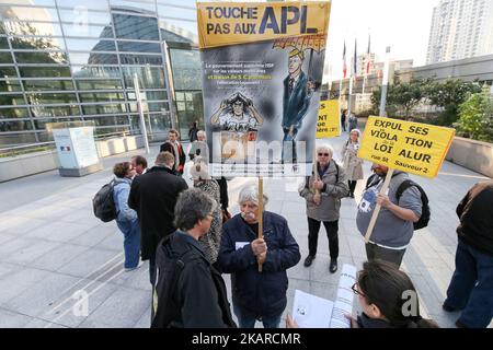 Ein Mann hält am 21. September 2017 ein Schild mit der Aufschrift ‘Don’t tuch to APL’dging bei einer Demonstration gegen die Reduzierung der Wohnungsleistung um €5 pro Monat vor dem Ministerium für territorialen Zusammenhalt im Geschäft des Distrikts La Defense in der Nähe von Paris, Frankreich. Auch die Wohnungsbauleistungen, in Frankreich als APL (Aide personnalisée au logement) bekannt, werden gekürzt. In einer Regierungserklärung vor dem französischen Fernsehen hieß es, dass die Wohnraumvorteile für jeden Antragsteller ab Oktober 2017 um €5 pro Monat reduziert werden. Zu den von den Kürzungen betroffenen Personen gehören 800.000 Studenten, die etwa €225 pro Monat erhalten, von denen mehrere nahmen Stockfoto