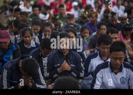 Rund 5,000 Balinesen versammeln sich am 30. September 2017 zum Massengebet für den Berg Agung und die Sicherheit in Denpasar, Bali, Indonesien. Die seismische Aktivität unterhalb des Mount Agung hat in den letzten Wochen mit Hunderten von Zittern jeden Tag zu einer Zunahme geführt. Über das Wochenende ist eine Rauchwolke aus dem Krater aufgestiegen. Mehr als 144,000 Menschen sind aus dem Gebiet um den Krater geflohen, und die Alarmstufe wurde am 22.. September auf den höchsten Stand angehoben. (Foto von Agoes Rudianto/NurPhoto) Stockfoto