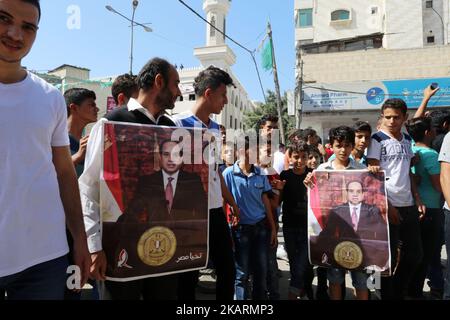 Die Menschen halten Plakate mit Porträts des ägyptischen Präsidenten Abdel Fattah al-Sisi, während sie sich versammeln, um den Konvoi des palästinensischen Premierministers Rami Hamdallah und seiner Regierungsminister am 2. Oktober 2017 im Gazastreifen zu beobachten. Hamdallah ist zu seinem ersten Besuch im Gazastreifen zu Gesprächen über eine Annäherung zwischen der Fatah und den Machthabern der Enklave, Hamas, unterwegs.(Foto von Momen Faiz/NurPhoto) Stockfoto