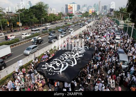 Indonesische muslimische Aktvisten halten während einer Kundgebung vor dem parlamentsgebäude in Jakarta, Indonesien, am 29. September 2017 eine riesige Flagge. Hunderte von Muslimen protestierten gegen ein Dekret, das der Regierung die Befugnis gibt, Gruppen, die sich der Staatsideologie widersetzen, ohne eine gerichtliche Entscheidung (die Verordnung in Lieu of Law) zu verbieten, und protestierten gegen die angebliche Rückkehr des Kommunismus in die politische Sphäre Indonesiens. Die Kommunistische Partei Indonesiens ist im Land weiterhin verboten. EDI Ismail (Foto von Edi Ismail/NurPhoto) Stockfoto