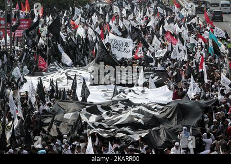 Indonesische muslimische Aktvisten halten während einer Kundgebung vor dem parlamentsgebäude in Jakarta, Indonesien, am 29. September 2017 eine riesige Flagge. Hunderte von Muslimen protestierten gegen ein Dekret, das der Regierung die Befugnis gibt, Gruppen, die sich der Staatsideologie widersetzen, ohne eine gerichtliche Entscheidung (die Verordnung in Lieu of Law) zu verbieten, und protestierten gegen die angebliche Rückkehr des Kommunismus in die politische Sphäre Indonesiens. Die Kommunistische Partei Indonesiens ist im Land weiterhin verboten. EDI Ismail (Foto von Edi Ismail/NurPhoto) Stockfoto