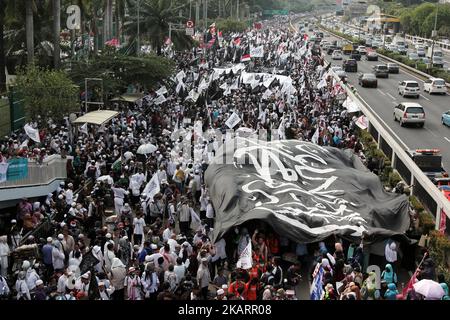 Indonesische muslimische Aktvisten halten während einer Kundgebung vor dem parlamentsgebäude in Jakarta, Indonesien, am 29. September 2017 eine riesige Flagge. Hunderte von Muslimen protestierten gegen ein Dekret, das der Regierung die Befugnis gibt, Gruppen, die sich der Staatsideologie widersetzen, ohne eine gerichtliche Entscheidung (die Verordnung in Lieu of Law) zu verbieten, und protestierten gegen die angebliche Rückkehr des Kommunismus in die politische Sphäre Indonesiens. Die Kommunistische Partei Indonesiens ist im Land weiterhin verboten. EDI Ismail (Foto von Edi Ismail/NurPhoto) Stockfoto