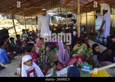 Rohingya-Kinder lernen am 11. Oktober 2017 in einer Madrasa im provisorischen Lager Balukhali in Cox's Bazar, Bangladesch, den Koran. Mehrere Tausend Rohingya, die vor der Gewalt in Myanmar fliehen, sind in Bangladesch eingestiegen, und offizielle Berichte über Kinder, die bei der jüngsten Flüchtlingswelle an Hunger, Erschöpfung und Fieber starben. (Foto von Mamunur Rashid/NurPhoto) Stockfoto