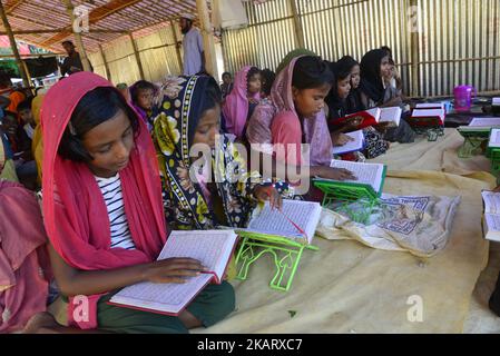 Rohingya-Kinder lernen am 11. Oktober 2017 in einer Madrasa im provisorischen Lager Balukhali in Cox's Bazar, Bangladesch, den Koran. Mehrere Tausend Rohingya, die vor der Gewalt in Myanmar fliehen, sind in Bangladesch eingestiegen, und offizielle Berichte über Kinder, die bei der jüngsten Flüchtlingswelle an Hunger, Erschöpfung und Fieber starben. (Foto von Mamunur Rashid/NurPhoto) Stockfoto