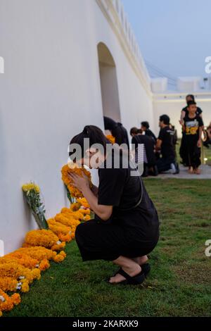 Am ersten Todestag von Thailands König Bhumibol Adulyadej stehen Tausende von thailändischen Trauernden vor den Toren des königlichen Palastes in Bangkok, um Blumen vor ein Bild des verstorbenen Königs zu legen und ihren Respekt zu zollen. (Foto von Thomas De Cian/NurPhoto) Stockfoto