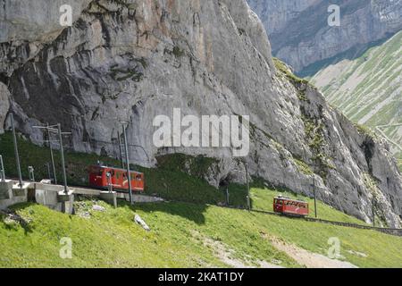 Zwei rote Zahnradzüge zwischen dem Bahnhof Alpnachstad und dem Berg Pilatus Kulm. Stockfoto