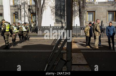 Demonstranten und Polizisten stehen in Kiew, Ukraine, am 22. Oktober 2017, mit einem Zaun getrennt. Dutzende Ukrainer bauten nach einer groß angelegten Kundgebung ein Zeltlager vor dem Parlament auf, um von den Gesetzgebern zu fordern, den Gesetzentwurf über sofortige politische Reformen wie die Schaffung eines Anti-Korruptionsgerichts, die Ablehnung der Unverletzlichkeit eines Abgeordneten und die Änderung der Wahlgesetze anzunehmen. (Foto von Sergii Chartschenko/NurPhoto) Stockfoto