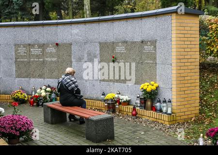 Frau sitzt vor einem Säulengarten mit Urne mit der Asche eines verstorbenen Familienmitglieds auf dem Garnisonsfriedhof in Danzig, Polen wird am 1. November 2017 gesehen Menschen feiern Allerheiligen (Wszystkich Swieych), respektieren die toten Familienmitglieder, Legen Sie Blumen und entzündeten Kerzen auf ihre Gräber. Allerheiligen am 1. November und Allerseelen-Tag am 2. November: Millionen von Polen besuchen die Gräber von Angehörigen und reisen oft Hunderte von Kilometern zu ihren Heimatstädten (Foto: Michal Fludra/NurPhoto) Stockfoto