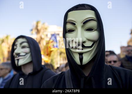 Aktivisten bedecken ihre Gesichter bei Demonstrationen mit den Guy Fawkes-Masken. Aktivisten der Unabhängigkeitsbefürworter hängen in den Straßen von Barcelona, Spanien, Plakate zur Unterstützung der katalanischen politischen Gefangenen und der nach der Unabhängigkeitserklärung Kataloniens am 5. November 2017 in Belgien verbannten Präsidentin Carles Puigdemont (Foto: Miquel Llop/NurPhoto) Stockfoto