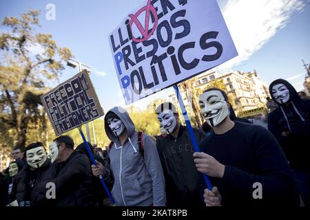 Aktivisten bedecken ihre Gesichter bei Demonstrationen mit den Guy Fawkes-Masken. Aktivisten der Unabhängigkeitsbefürworter hängen in den Straßen von Barcelona, Spanien, Plakate zur Unterstützung der katalanischen politischen Gefangenen und der nach der Unabhängigkeitserklärung Kataloniens am 5. November 2017 in Belgien verbannten Präsidentin Carles Puigdemont (Foto: Miquel Llop/NurPhoto) Stockfoto