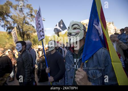 Aktivisten bedecken ihre Gesichter bei Demonstrationen mit den Guy Fawkes-Masken. Aktivisten der Unabhängigkeitsbefürworter hängen in den Straßen von Barcelona, Spanien, Plakate zur Unterstützung der katalanischen politischen Gefangenen und der nach der Unabhängigkeitserklärung Kataloniens am 5. November 2017 in Belgien verbannten Präsidentin Carles Puigdemont (Foto: Miquel Llop/NurPhoto) Stockfoto