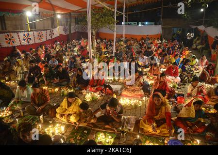 Hunderte von Hindus-Anhängerinnen sitzen mit Lichtkerze, um am 14. November 2017 ein religiöses Hindu-Fest Rakher Upabas im Shamibag Loknath Dham in Dhaka, Bangladesch, zu feiern. Sitzen vor Kerzen Licht und absorbieren im Gebet Lokenath Brahmachari, der genannt wird Baba Lokenath war ein 18. Jahrhundert Hindu-heiliger und Philosoph in Bengalen. Hindu-Anbeter fasten und beten ernsthaft zu den Göttern für ihre Gunst während des traditionellen Rituals, das Kartik Brati oder Rakher Upobash genannt wird. (Foto von Mamunur Rashid/NurPhoto) Stockfoto