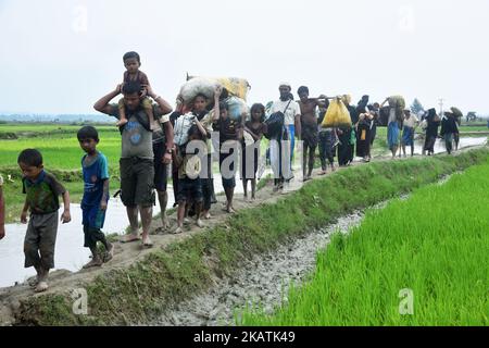 Hunderte von Rohingya überqueren die Grenze zu Bangladesch, als sie aus dem Bundesstaat Rakhain in Myanmar fliehen, nachdem sie am 06. September 2017 in Tagnuf, Bangladesch, den Fluss Nuf überquert haben. Nach Angaben des Hohen Flüchtlingskommissars der Vereinten Nationen (UNHCR) sind im vergangenen Monat mehr als 525.000 Rohingya-Flüchtlinge aus Myanmar wegen Gewalt geflohen, wobei die meisten von ihnen versuchten, die Grenze nach Bangladesch zu überschreiten. Internationale Organisationen haben Behauptungen über Menschenrechtsverletzungen und summarische Hinrichtungen gemeldet, die angeblich von der Armee von Myanmar durchgeführt wurden. (Foto von Mamunur Rashid/NurPhoto) Stockfoto