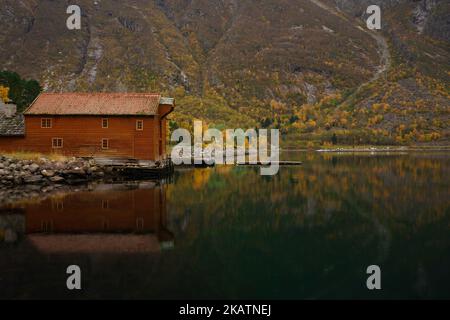 Herbst / Herbst Landschaft Fjordwasser mit orangefarbenem Bootshaus 'Sjøbua', geschütztes Gebäude im Eidfjord Norwegen Hardangerfjord Stockfoto