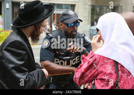 Ein ultra-orthodoxer jüdischer Rabbi und eine Palästinenserin sprechen mit einem Mitglied der Polizei von Toronto während einer Demonstration in Toronto, Kanada, am 29. Juli 2017. Muslime und Juden kamen zusammen, um gegen Israel zu protestieren und Solidarität mit Palästina zu zeigen. (Foto von Creative Touch Imaging Ltd./NurPhoto) Stockfoto