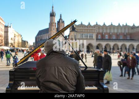 Arne Schmitt, ein deutscher Pianist und Straßenmusiker, tritt auf dem Krakauer Hauptplatz auf. Im Alter von 29 Jahren gab Arne Schmitt seinen Job in einer Autowerkstatt auf und spielte dann Vollzeit auf der Straße. Seit 1997 reist er - zunächst als Teilzeit - mit einem Klavier durch Europa und hat bereits in mehr als 300 Städten gespielt. Am Sonntag, den 10. Dezember 2017, in Krakau, Polen. (Foto von Artur Widak/NurPhoto) Stockfoto