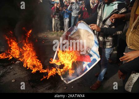 Palästinensische Demonstranten verbrennen ein Plakat, auf dem US-Präsident Donald Trump während eines Protestes gegen Trumps Entscheidung, Jerusalem in der Nähe des zentralen Gazastreifens als Hauptstadt Israels anzuerkennen, dargestellt wird. 15. Dezember 2017. (Foto von Majdi Fathi/NurPhoto) Stockfoto