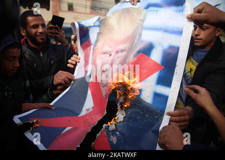 Palästinensische Demonstranten verbrennen ein Plakat, auf dem US-Präsident Donald Trump während eines Protestes gegen Trumps Entscheidung, Jerusalem in der Nähe des zentralen Gazastreifens als Hauptstadt Israels anzuerkennen, dargestellt wird. 15. Dezember 2017. (Foto von Majdi Fathi/NurPhoto) Stockfoto