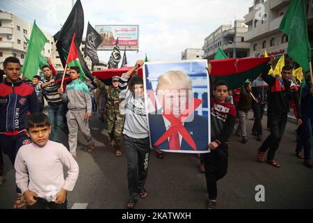 Palästinensische Demonstranten verbrennen ein Plakat, auf dem US-Präsident Donald Trump während eines Protestes gegen Trumps Entscheidung, Jerusalem in der Nähe des zentralen Gazastreifens als Hauptstadt Israels anzuerkennen, dargestellt wird. 15. Dezember 2017. (Foto von Majdi Fathi/NurPhoto) Stockfoto