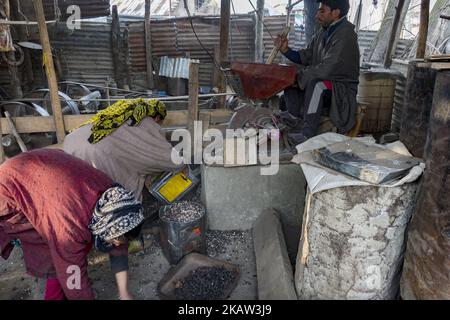 Ein Kashmiri mahlt am 05. Januar 2018 in Kolhom, nördlich von Srinagar, der Sommerhauptstadt des indischen Kaschmir, in Indien, Wasserkastanien, um Mehl in einer Mühle zu erhalten. Wasserkastanien sind eine wichtige Nutzpflanze für Menschen, die in der Nähe des Wular Lake, Asiens zweitgrößtem Süßwassersee, leben. Wular, sieht im Winter eher wie eine flache sumpfige Ebene als ein großer See aus, da der Wasserstand zurückgeht ganze Familien sammeln und extrahieren die marmorgroße Frucht aus seiner Stachelhülle . Die sonnengetrockneten Kastanien werden später auf den Märkten, insbesondere in der Sommerhauptstadt Srinagar, verkauft und roh oder geröstet und sogar verzehrt Stockfoto