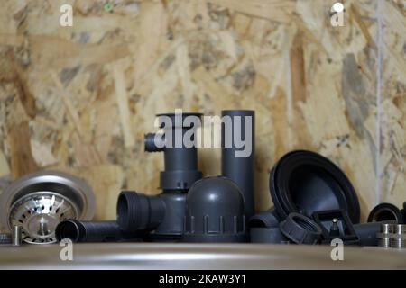 Klempner Werkzeuge und Wasserhahn bereit für die Installation in der Nähe von Waschbecken auf Arbeitsplatte in der Küche. Anschlüsse für den Einbau des Wasserhahns für den k Stockfoto