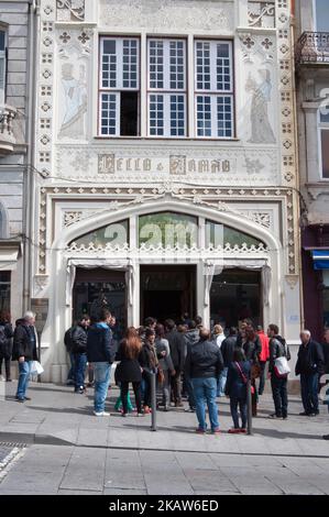 Eine vertikale Aufnahme von Menschen vor der Fassade des Buchladens „Livraria Lello“ im Zentrum von Porto, Portugal Stockfoto