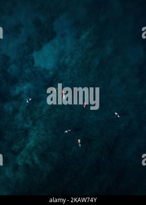 Eine Luftaufnahme von Menschen, die im dunkelblauen Wasser auf Hawaii Kajak surfen Stockfoto