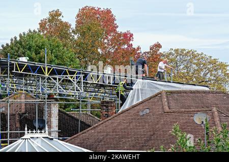 Gerüste, die vor den Bauarbeiten am Dach ein Gerüst auf einem Vorstadtbungalow errichten, Shepperton England, Großbritannien Stockfoto
