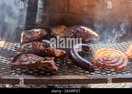 Nahaufnahme des argentinischen Grills auf dem Grill. Kurze Rippen, Spulen von gegrillter Wurst und eine Blutwurst, Rindfleisch Stockfoto