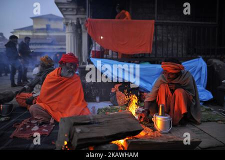 Hindu-Sadhus oder Heiliger Mann wärmen sich am Montag, den 12. Februar 2018, an einem Abend auf dem Gelände des Pashupatinath-Tempels in Kathmandu, Nepal, auf Holzfeuer. Tausende Hindu-Sadhu oder Heiliger aus Indien und Nepal feiern am Dienstag, den 13. Februar 2018, das Maha Shivaratri-Fest im Pashupatinath-Tempel in Nepal. (Foto von Narayan Maharjan/NurPhoto) Stockfoto