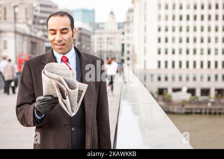 London Professionals, Gute Nachrichten. Ein elegant gekleideter südasiatischer Geschäftsmann in der Finanzstadt London. Aus einer Reihe verwandter Bilder. Stockfoto