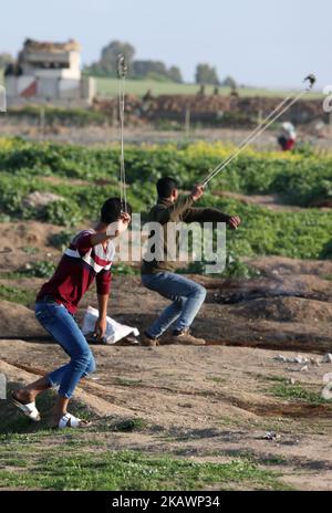 Palästinensische Demonstranten werfen am 23. Februar 2018 bei Zusammenstößen in der Nähe des Grenzzauns östlich von Gaza-Stadt einen Stein auf israelische Soldaten. (Foto von Majdi Fathi/NurPhoto) Stockfoto