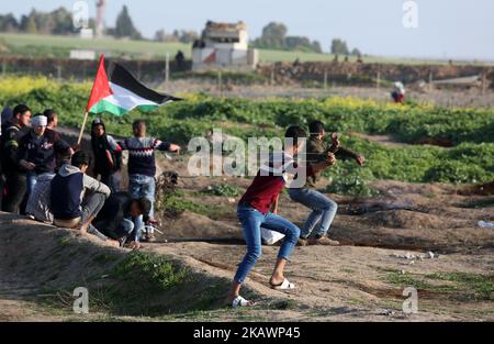 Palästinensische Demonstranten werfen am 23. Februar 2018 bei Zusammenstößen in der Nähe des Grenzzauns östlich von Gaza-Stadt einen Stein auf israelische Soldaten. (Foto von Majdi Fathi/NurPhoto) Stockfoto