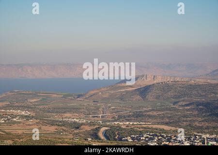 Der See von Galilee mit dem Dorf und dem Berg Arbel, Golanhöhen im Hintergrund, Israel, Luftaufnahme Stockfoto