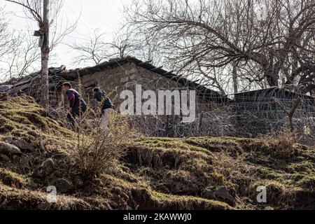 URI, KASCHMIR, INDIEN – FEBRUAR 27: Kashmiri-Männer gehen vor dem Bunker der indischen Armee, während sie am 27. Februar 2018 in Uri, 120 km (75 Meilen) nordwestlich von Srinagar, der Sommerhauptstadt des indischen verwalteten Kaschmir, in Indien, in Richtung ihres verlassenen Hauses gehen. Das Dorf mit einer Bevölkerung von etwas mehr als 12.000 Einwohnern hat die Hauptlast des Kreuzfeuers zwischen den nuklearen Rivalen Indien und Pakistan zu tragen. Menschen, die entlang der Waffenstillstandsgrenze leben, die Kaschmir in Indien und von Pakistan verwaltete Teile teilt, sind aufgrund der Feindseligkeit zwischen den ständig gefährdet Stockfoto