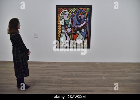 Eine Frau betrachtet „Girl before a Mirror“ von Pablo Picasso in der Tate Modern am 6. März 2018 in London, England. „Picasso 1932: Love, Fame and Tragedy“ ist die erste Einzelausstellung des Künstlers in der Tate Modern und umfasst mehr als 100 Werke. (Foto von Alberto Pezzali/NurPhoto) Stockfoto