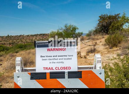 Ein Warnzeichen eines geschlossenen Pfadtextes, Bienenschwarm in der Nähe von Rimrock, Arizona unter einem blauen Himmel Stockfoto