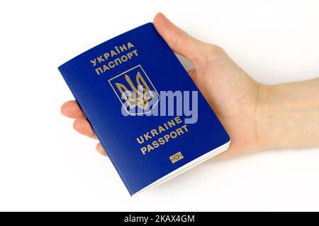 Ukrainischer biometrischer Pass in weiblicher Hand auf weißem Hintergrund. Inschrift im ukrainischen Pass der Ukraine Stockfoto