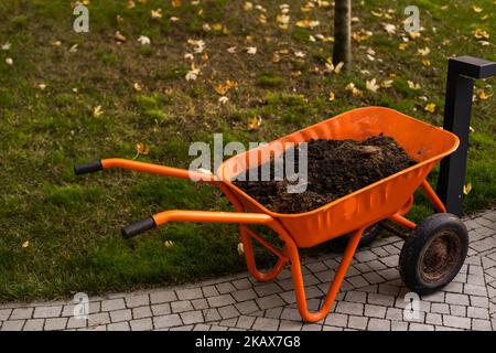 Garten-Schubkarre gefüllt mit Erde auf einem Bauernhof Stockfoto
